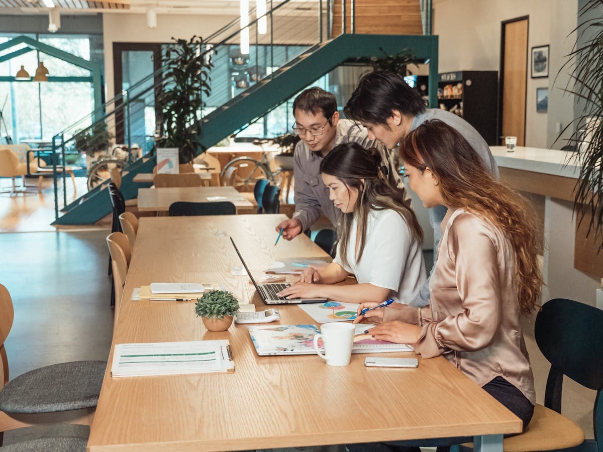 Creator planning a flagship launch with a laptop, notebook, and launch materials spread across a warm workspace.